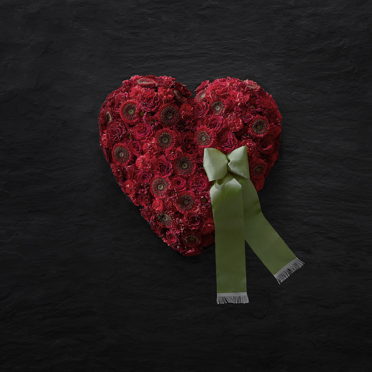 Ein rotes Blumenherz spricht für sich – es bringt die über den Tod hinaus fortwährende Liebe zu der Verstorbenen Person zum Ausdruck. Blumenherzen können ebenfalls mit einer Schleife versehen werden.