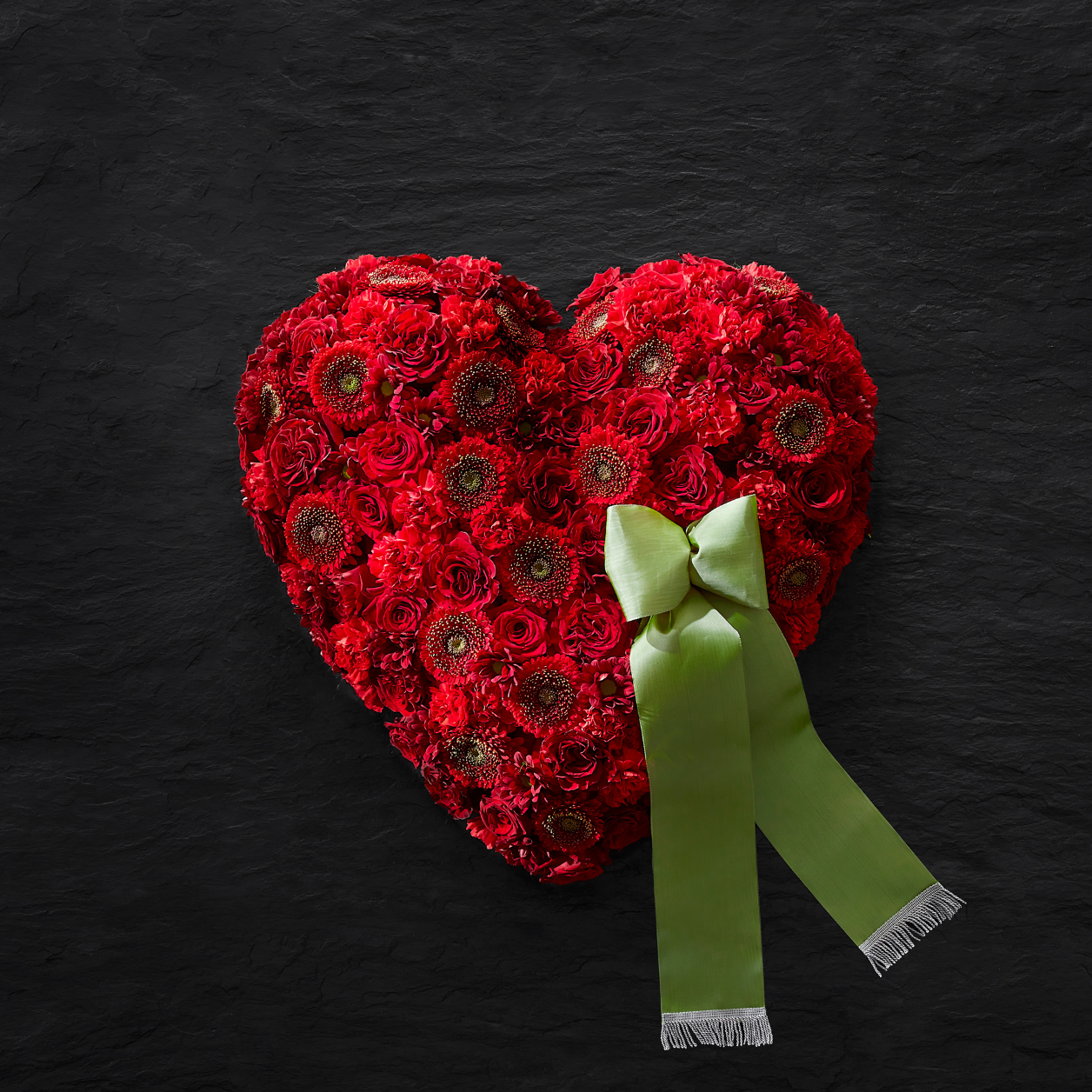 Bild 2: Ein rotes Blumenherz spricht für sich – es bringt die über den Tod hinaus fortwährende Liebe zu der Verstorbenen Person zum Ausdruck. Blumenherzen können ebenfalls mit einer Schleife versehen werden.