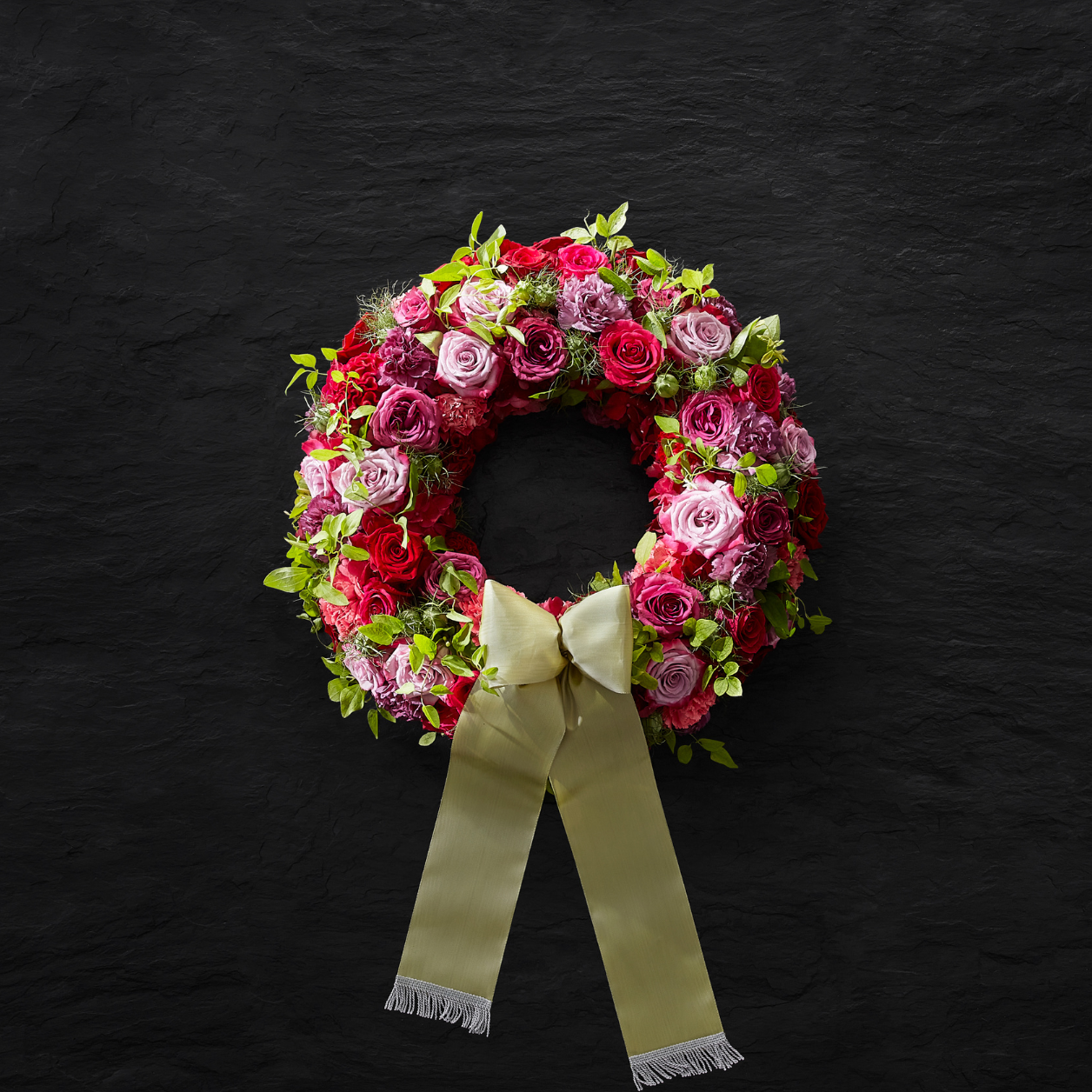 Bild 1: Rosa in Kombination mit kräftigeren Farben ergeben eine sehr schöne Wirkung. Urnenbestattungskränze können ebenfalls mit einer Schleife versehen werden.